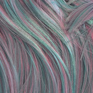 May include: A collection of straight hair strands featuring a blend of pastel pink, soft teal, and muted lavender tones. The hair is layered and textured, creating a multi-dimensional appearance with fine, individual strands visible throughout the image.