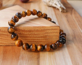 May include: A brown tiger's eye beaded bracelet with a natural stone finish.