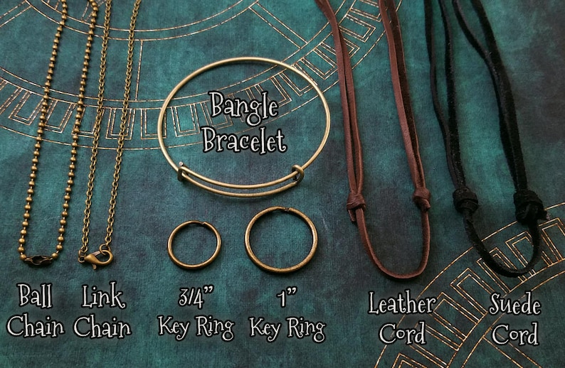 May include: A comparison of different types of necklace chains and cords.  The chains include a ball chain, a link chain, and a bangle bracelet.  The cords include a leather cord and a suede cord.  The chains and cords are shown with key rings in 3/4 inch and 1 inch sizes.