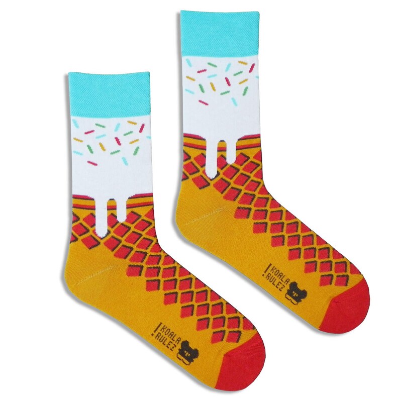 May include: A pair of yellow and red socks with a white ice cream cone design and colourful sprinkles. The socks have the text "Koala Rulez" on the bottom.