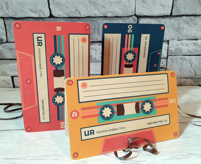 May include: Three vintage cassette tapes with colorful designs. The tapes are labeled "UR" and "90" and have the text "POSITION NORMAL TYPE I" and "HIGH BIAS 7US EQ".