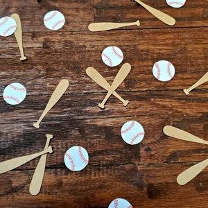Könnte beinhalten: Eine Sammlung brauner Holz-Baseballschläger und weißer Baseballs mit roten Nähten, die auf einer braunen Holzoberfläche verstreut sind.