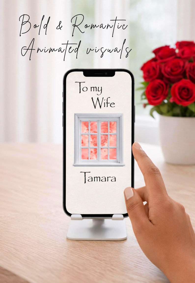 Pu&ograve; includere: Uno smartphone mostra un'immagine digitale con la scritta "To my Wife" e il nome "Tamara". L'immagine sullo schermo presenta un telaio di finestra bianco con uno sfondo rosa e rosso. Un mazzo di rose rosse &egrave; sullo sfondo.