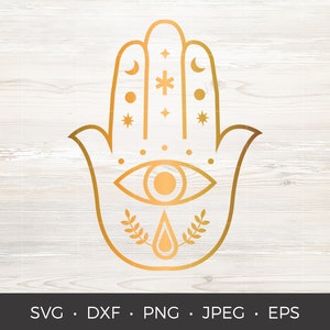 May include: A gold-colored Hamsa hand design with an eye, crescent moons, stars, and a teardrop shape. The image is on a light wood grain background. The bottom of the image includes the text: SVG, DXF, PNG, JPEG, EPS.