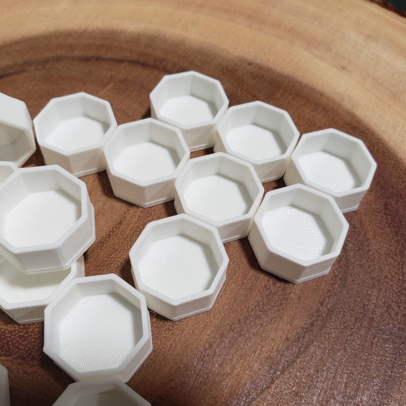 May include: A set of white octagonal containers, arranged in a honeycomb pattern. The containers are made of a smooth, white plastic and are perfect for storing small items.