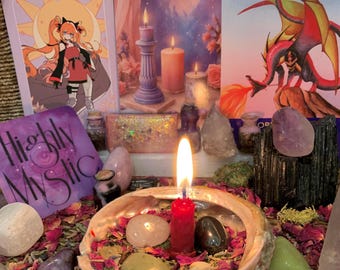 May include: A collection of spiritual items including three illustrated cards, a burning red candle in an abalone shell, various polished gemstones, dried flower petals, and a purple square card with the text Highly Mystic printed in black.