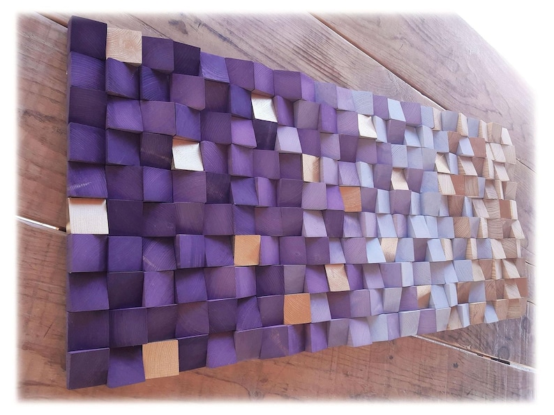 a wooden surface with a textured pattern composed of small square tiles in shades of purple and beige.