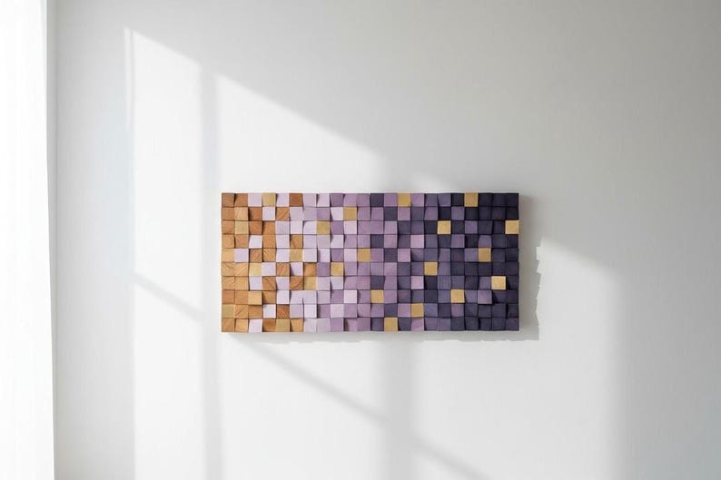a rectangular wooden block art piece with a gradient of purple and orange colors, mounted on a white wall.