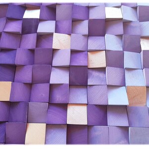 The image is a close-up of a textured surface composed of numerous small square wooden blocks in various shades of purple and light brown. The blocks are arranged in a grid-like pattern, creating a visually striking and intricate design.