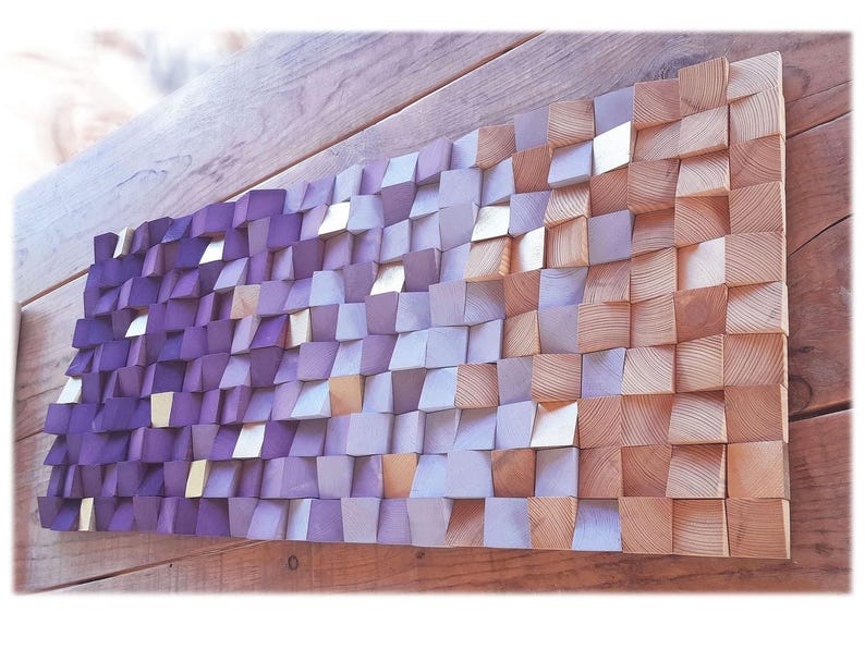 a wooden surface with a textured, mosaic-like pattern composed of small, square-shaped wooden blocks in various shades of purple and orange.