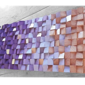 a large, colorful, and intricate piece of wall art composed of numerous small, square-shaped wooden blocks in various shades of purple and orange. The blocks are arranged in a visually striking pattern, creating a vibrant and eye-catching display.