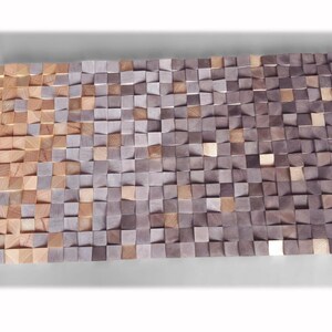 a large, rectangular arrangement of small, square-shaped wooden blocks in various shades of brown and gray, creating a textured and visually interesting surface.