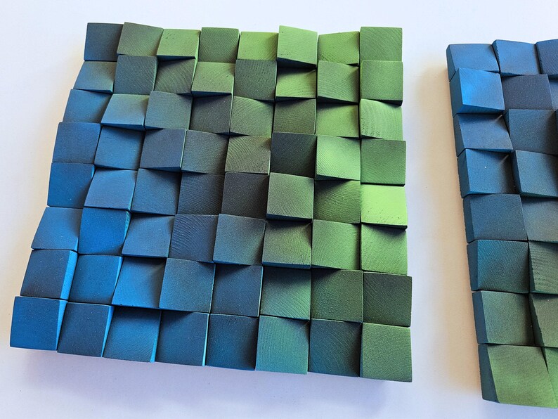 a square-shaped arrangement of small, square-shaped blocks in various shades of green and blue, creating a visually striking and textured surface.