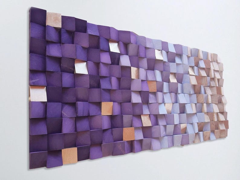 a large, abstract wall art piece composed of numerous small, square-shaped wooden blocks in various shades of purple and brown. The blocks are arranged in a grid-like pattern, creating a visually striking and textured surface.