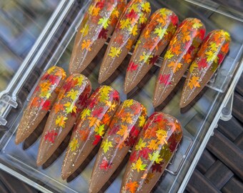 Uñas postizas con hojas caídas brillantes doradas