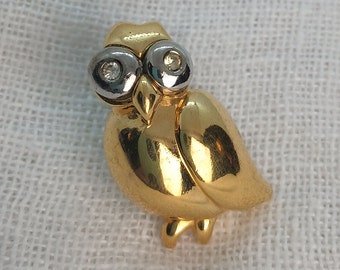 Vintage uilbroche: goud- en zilverkleur met strassteenogen