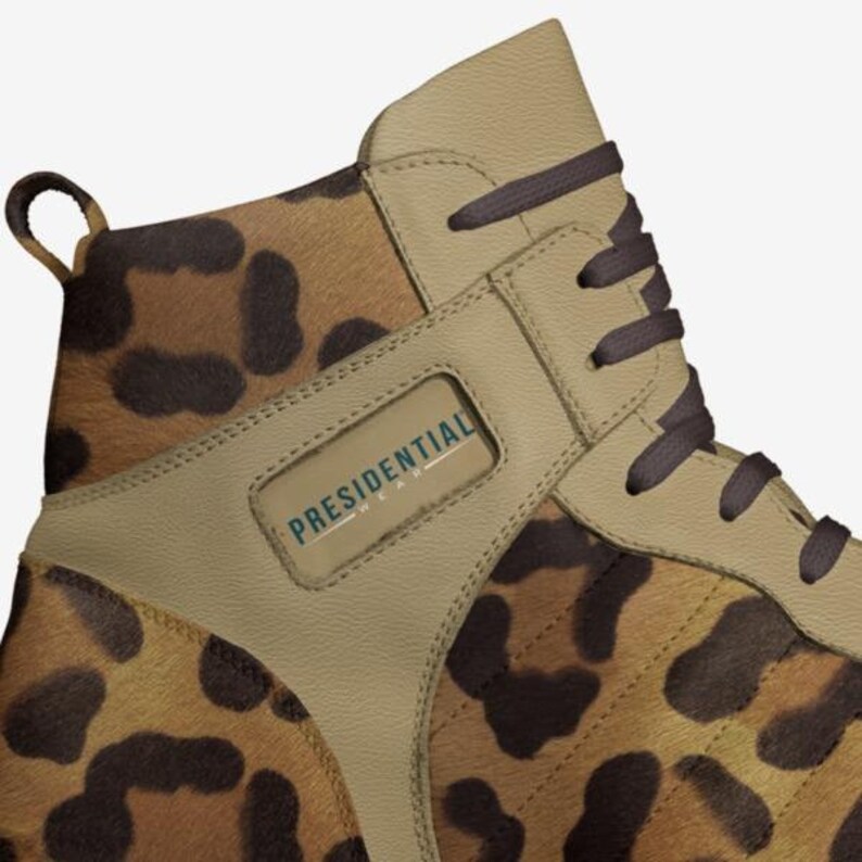 May include: Close-up of a brown and tan high-top sneaker with a leopard print design. The shoe has a brown lace and a white label with the text "PRESIDENTIAL WEAR" on the side.