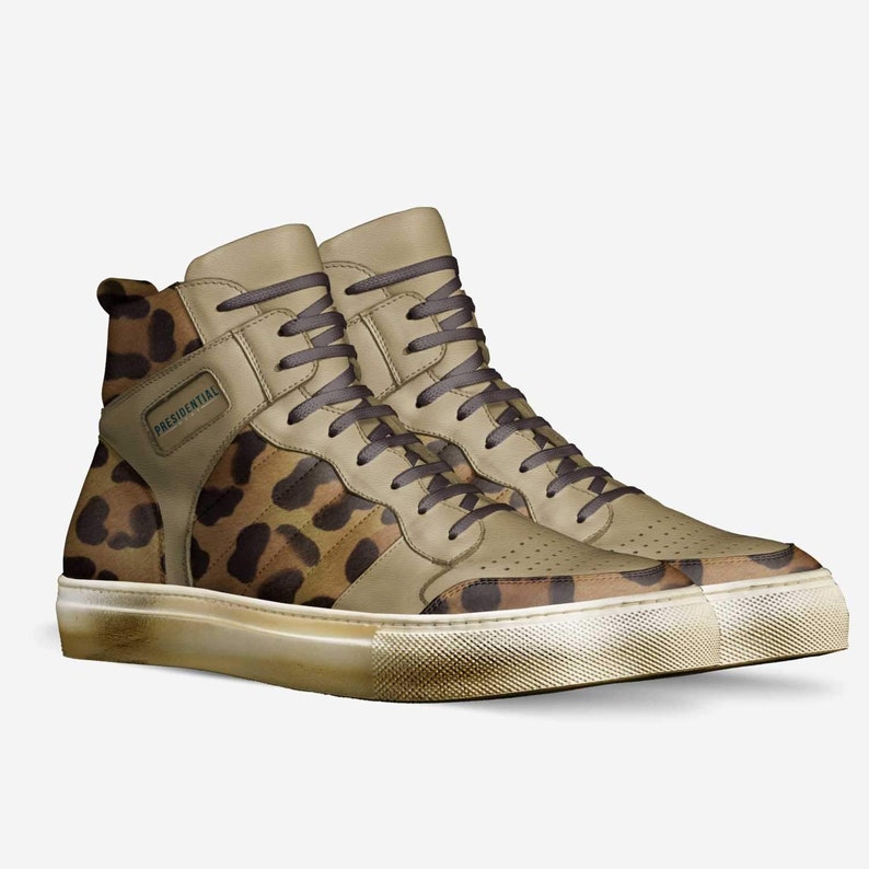 May include: A pair of high-top sneakers with a leopard print design. The shoes have a white sole and a brown leather upper with the word "PRESIDENTIAL" on the side.