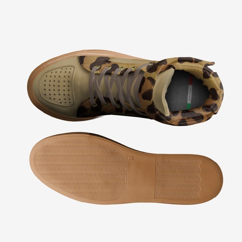 May include: A pair of high-top sneakers with a brown and tan leopard print upper, a brown leather toe, and a brown rubber sole. The sneakers have a lace-up closure and a padded tongue.