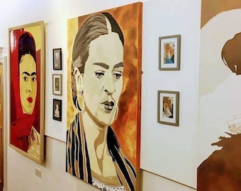 Op de afbeelding: Een galeriewand met drie schilderijen. Het middelste schilderij is een portret van een vrouw met donker haar en een zwart-wit gestreepte sjaal. Het schilderij links is een portret van een vrouw met rood haar en een rode sjaal. Het schilderij rechts is een silhouet van een vrouw in een vloeiende jurk.