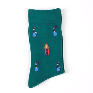 May include: A pair of green socks with a pattern of women in dresses and a woman in a red coat.