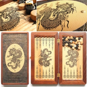 May include: A wooden backgammon set with a dragon design. The set is closed and features a brown leather-like exterior. The interior is made of wood and features a dragon design. The set includes black and white counters and two dice.