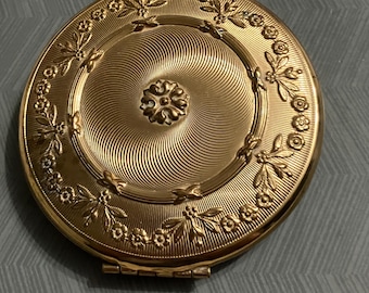 Polvos compactos franceses con estuche estilo reloj de bolsillo.