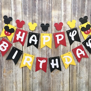 May include: A red, yellow, and black banner with the words "Happy Birthday" in white letters. The banner is decorated with Mickey Mouse ears and heads.