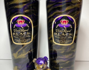 May include: Two tall tumblers with black, gold, and purple swirling patterns, featuring the "Crown Royal Black" logo. A geometric bear figurine in matching colors sits on a mirrored surface, adding a decorative touch to the set.