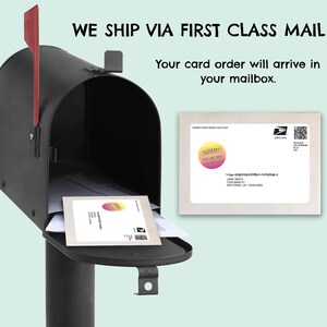 May include: A black metal mailbox with a red flag, containing a white envelope with a circular sticker that reads HOORAY! YOUR CARD ORDER HAS ARRIVED. A second identical envelope is shown to the right with a USPS postage label and address.