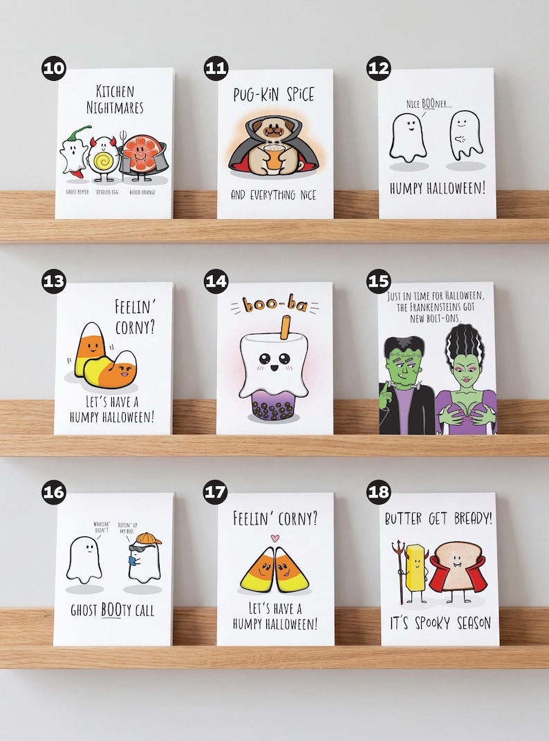 May include: A collection of nine rectangular greeting cards featuring cartoon illustrations and puns for Halloween. Each card displays unique characters like ghosts, candy corn, and food items with text captions, arranged in three rows on wooden shelves.