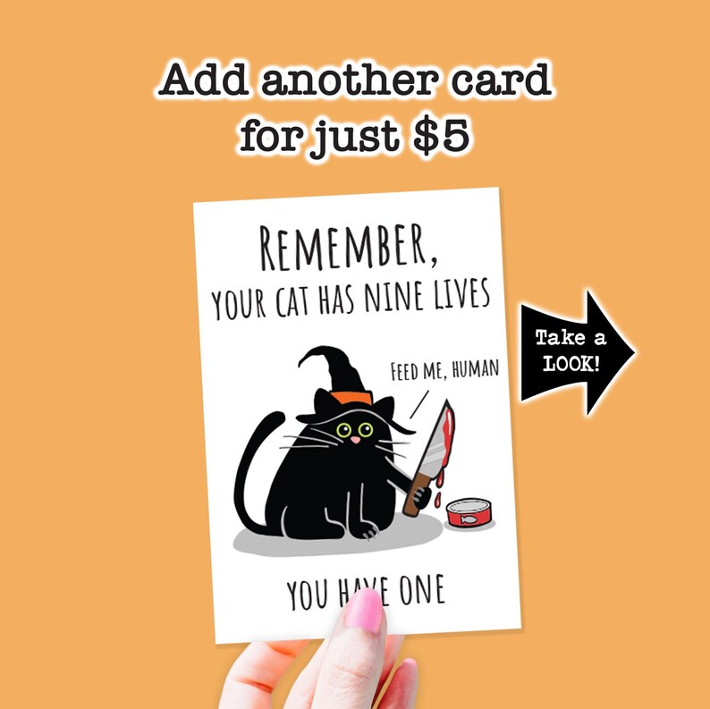 May include: A white greeting card featuring a black cat wearing a witch hat and holding a bloody knife. The text reads: REMEMBER, YOUR CAT HAS NINE LIVES. FEED ME, HUMAN. YOU HAVE ONE. A black arrow points to the right with the text: Take a LOOK!