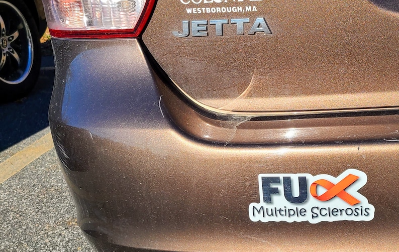 May include: A brown car with a sticker that says "FUX Multiple Sclerosis" with an orange ribbon.