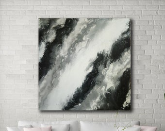 May include: Abstract painting in shades of black, white, and gray. The painting features a diagonal line of white paint with black and gray paint surrounding it. The painting is hanging on a white brick wall in a living room setting.