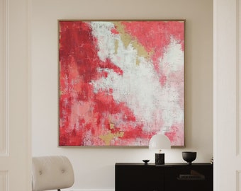 May include: Abstract painting with red, white, and gold paint on a canvas. The painting is framed in a gold frame and is hanging on a white wall.