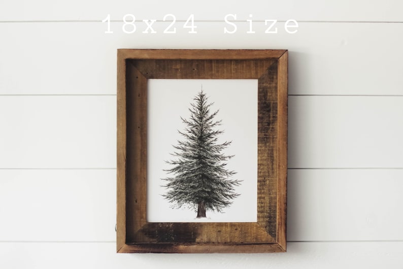 May include: A black and white illustration of a pine tree in a brown wood frame. The frame is 18 inches by 24 inches.