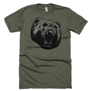 May include: A green t-shirt with a black and white graphic of a bear's head with its mouth open.