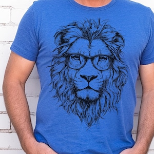 May include: A blue t-shirt featuring a black and white illustration of a lion wearing glasses.