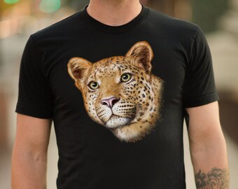 Op de afbeelding: Een zwart T-shirt met een close-up afbeelding van een luipaardkop. De luipaard heeft bruine en zwarte vlekken en groene ogen.