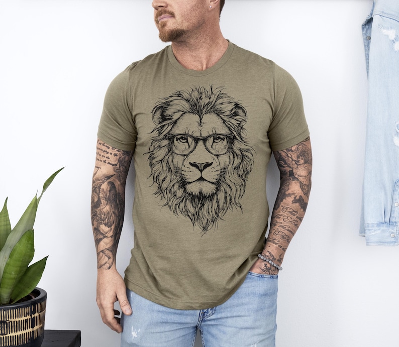 May include: A green t-shirt featuring a black and white illustration of a lion wearing glasses.