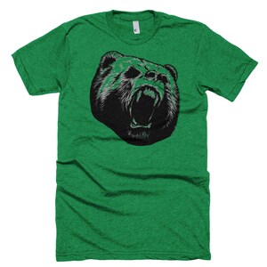 May include: A green t-shirt with a black and white graphic of a bear's face with its mouth open.