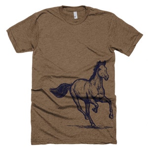 May include: A brown t-shirt with a navy blue silhouette of a horse running to the right side of the shirt.