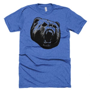 May include: A blue t-shirt with a black and white graphic of a bear's head with its mouth open and teeth showing.
