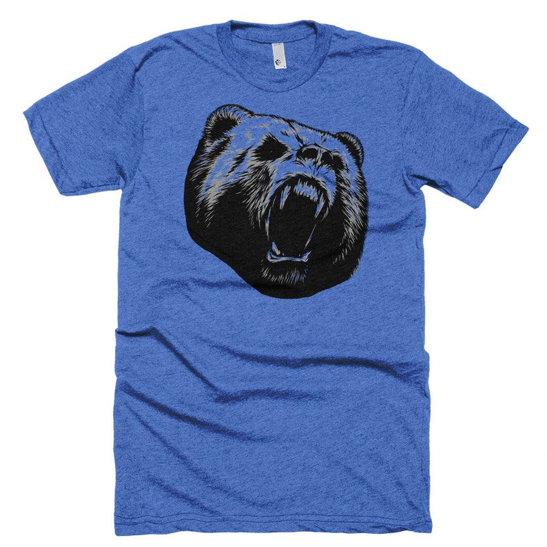 May include: A blue t-shirt with a black and white graphic of a bear's head with its mouth open and teeth showing.