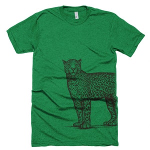 May include: A green t-shirt with a black and white illustration of a leopard on the right side of the shirt.