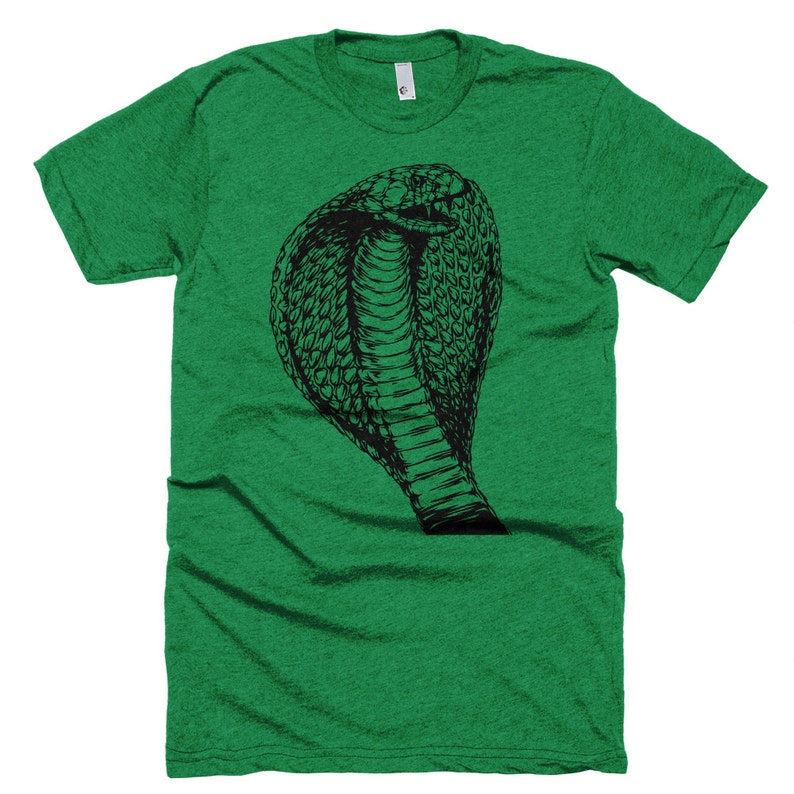 May include: A green t-shirt with a black and white illustration of a cobra snake with its hood raised.