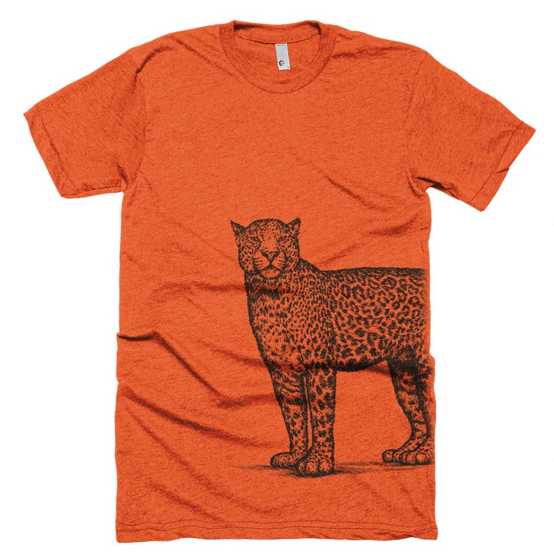 May include: Orange t-shirt with a black and white illustration of a leopard on the right side of the shirt.