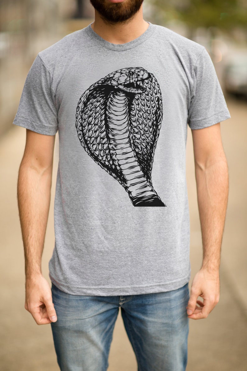 May include: A gray t-shirt with a black and white illustration of a cobra snake with its hood raised.