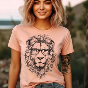 May include: A peach-coloured t-shirt with a black and white illustration of a lion wearing glasses.