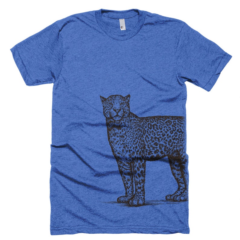 May include: A royal blue t-shirt with a black and white illustration of a leopard on the right side of the shirt.